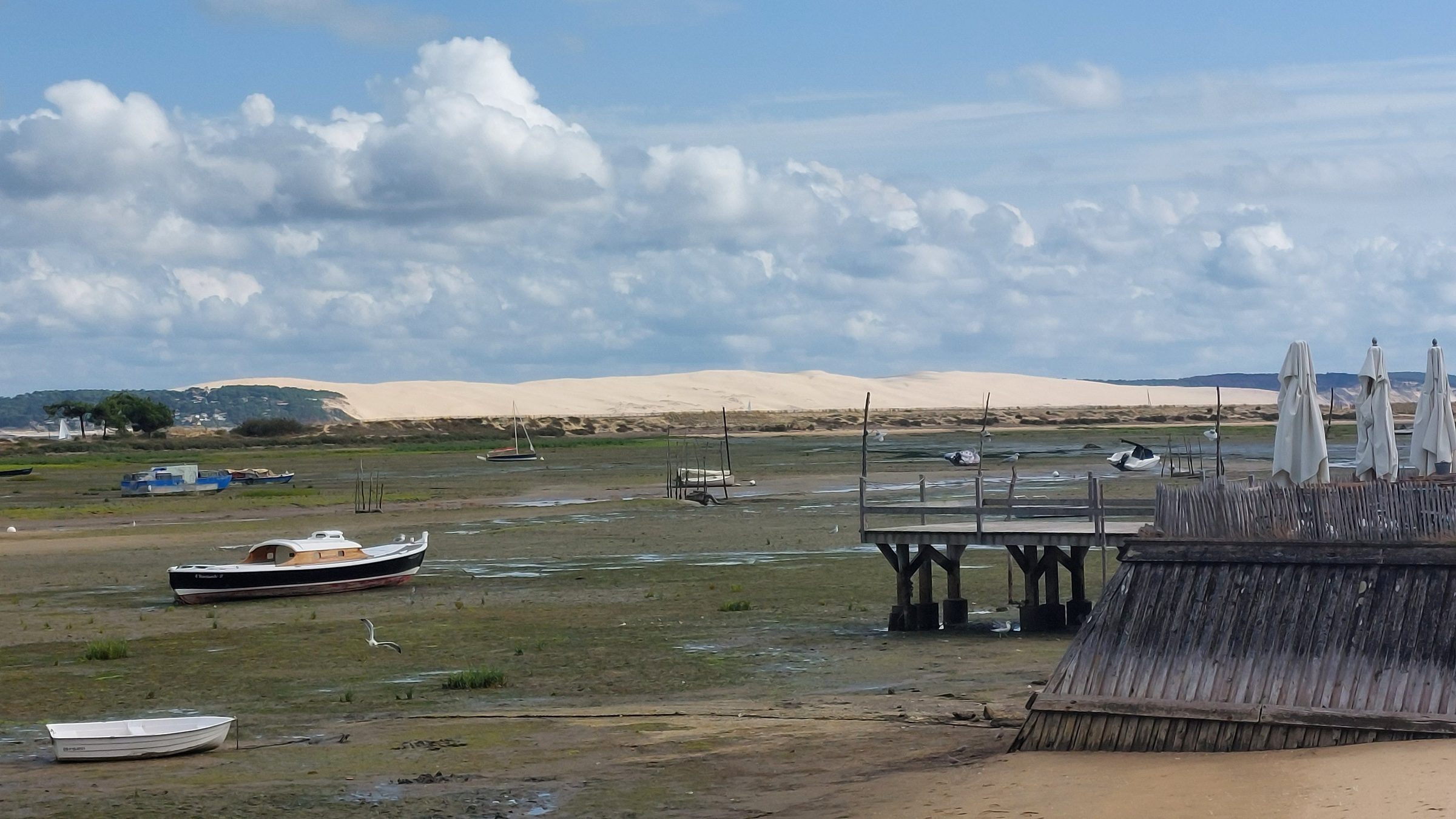 Le bassin à marée basse : bateaux échoués, ponton et dune du Pilat au loin
