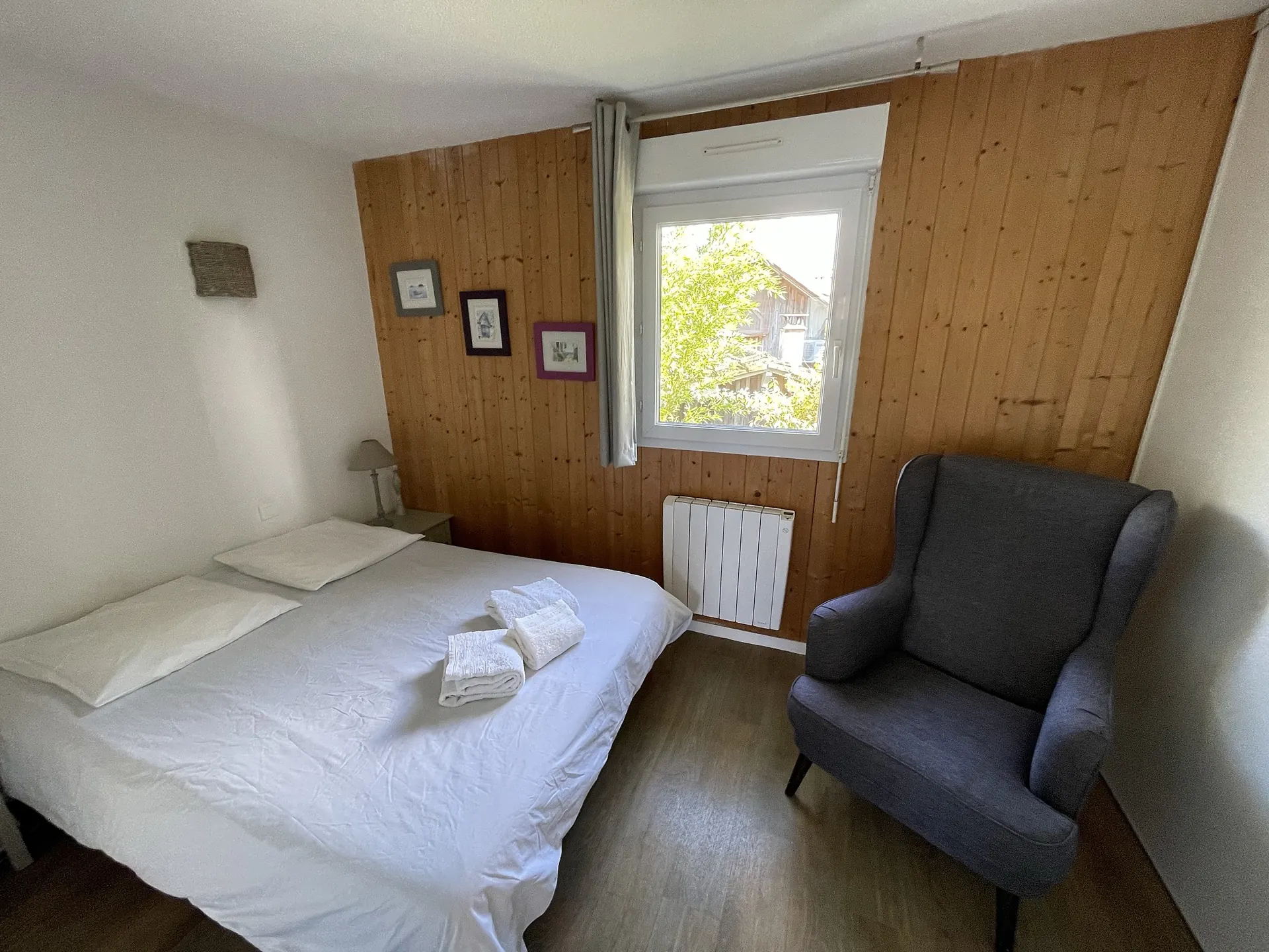 Chambre à l’étage, mur en lambris : le lit est fait et les serviettes vous attendent dessus
