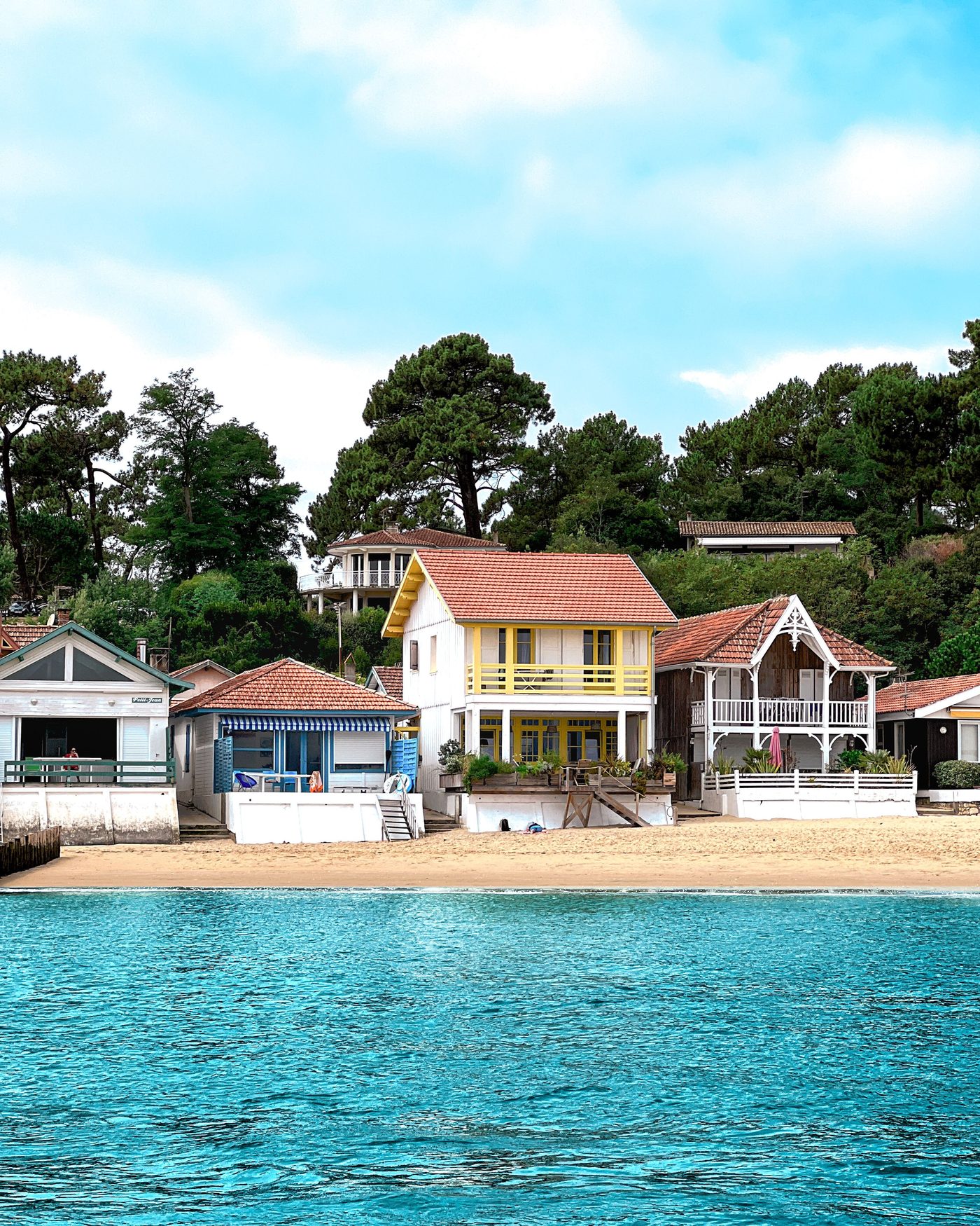 Cabanes en bois colorées du bassin, vues depuis l’eau